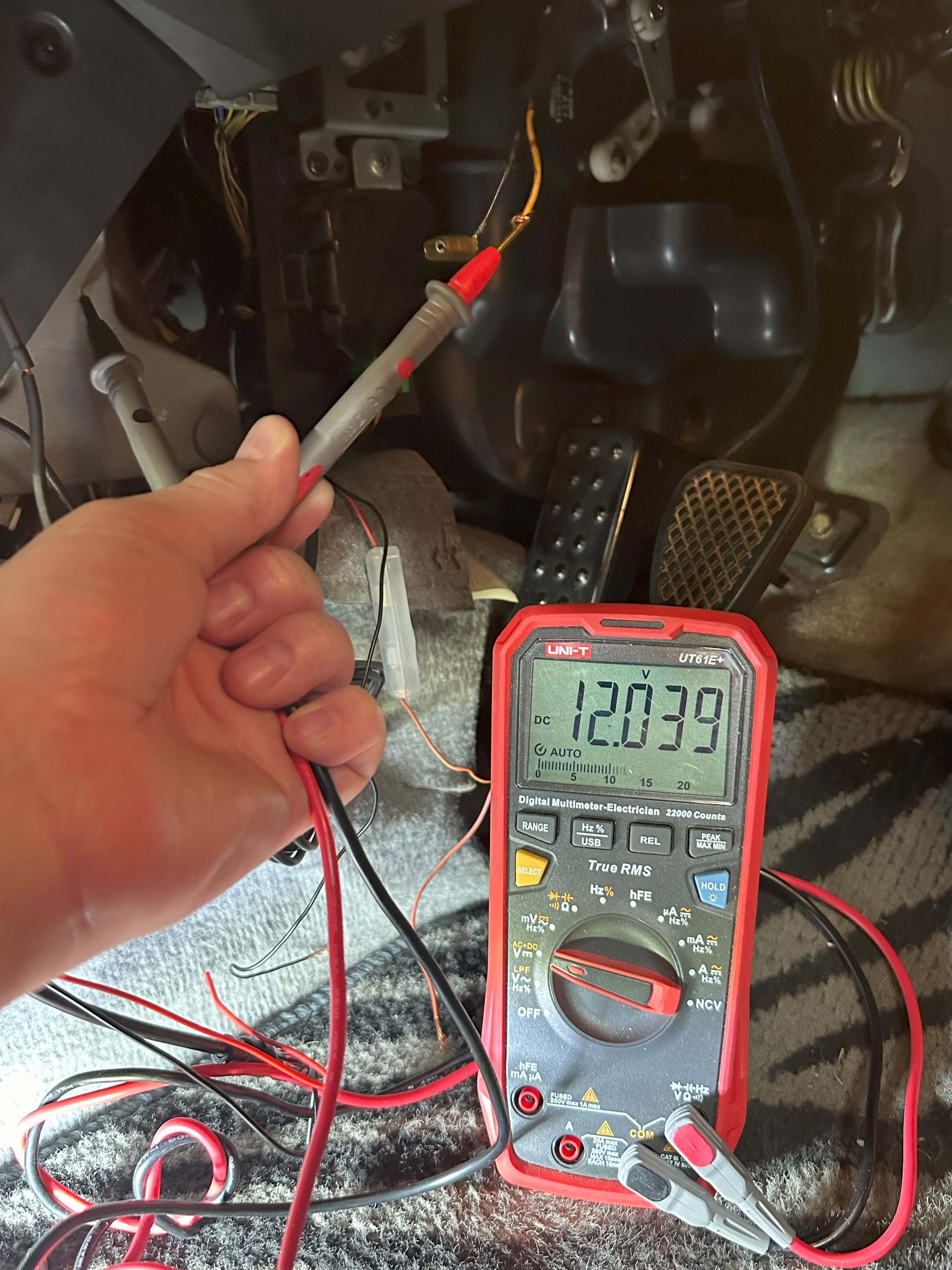 Picture of a multimeter finding a 12v source.