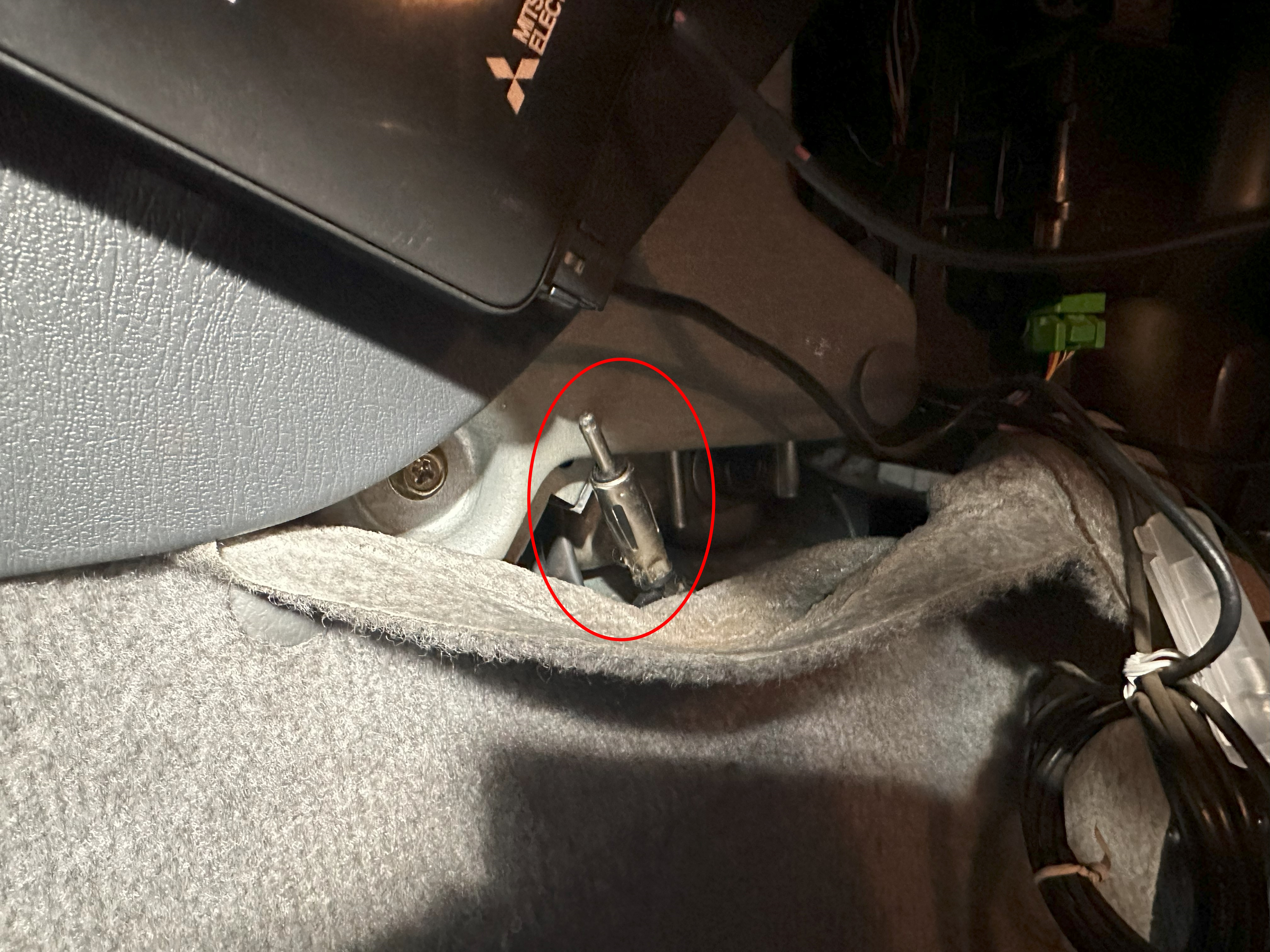 Picture of the antenna cable unplugged from the head unit and circled in red.